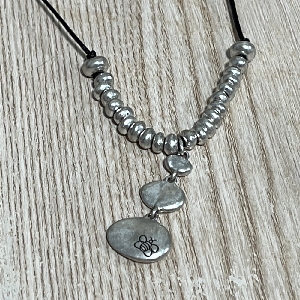 Bella Uno Silver beads on black cord with bumblebees stamped in it